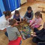 Dzieci siedzą wokół gry planszowej 