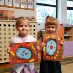 Na zdjęciu dwie dziewczynki prezentują swoje prace plastyczne .jpg
