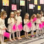 Na zdjęciu dziewczynki z grupy I,  ubrane na biało , w rękach trzymają laleczki zrobione z różowej chustki.  