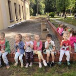Festyn w wojsku. Zdjęcie przedstawia grupę dzieci siedzącą i jedzącą lody na patyku. jpg