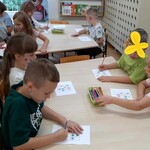 Dzieci siedzą przy stolikach z Sudoku.
