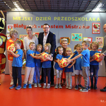 DZIEŃ PRZEDSZKOLAKA 2024. Grupa dzieci razem z p. Iwonką pozują do wspólnego zdjęcia z maskotką Jagielloni.jpg