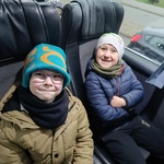 Dwóch uśmiechniętych chłopców siedzi w autokarze w drodze powrotnej do przedszkola.