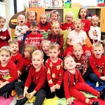 Pamiątkowe zdjęcie urodzinowo - mikołajkowe. Dzieci na tle szafek pozują do wspólnego zdjęcia. Wszyscy ubrani są na czerwono.- 5.jpg